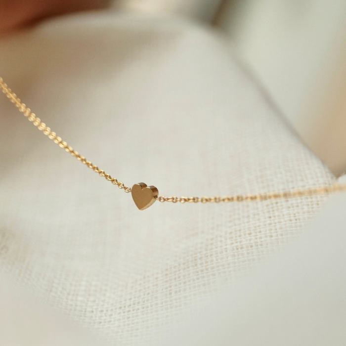 Gouden Minitials armband met hanger op een wit doek